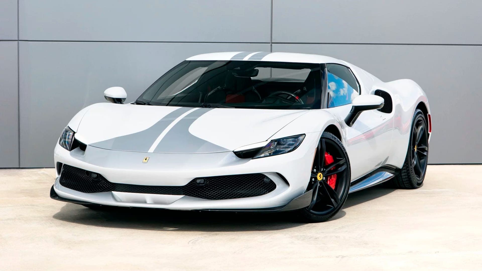 White Ferrari 296 GTB with grey racing stripe, front three-quarter view