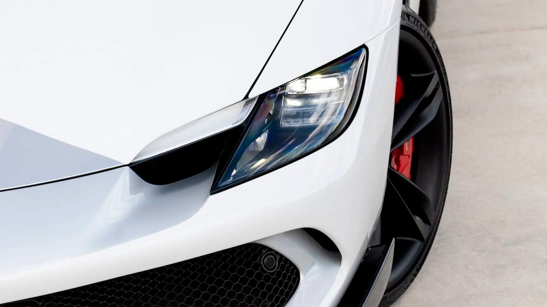 Ferrari 296 GTB headlight and red brake caliper close-up