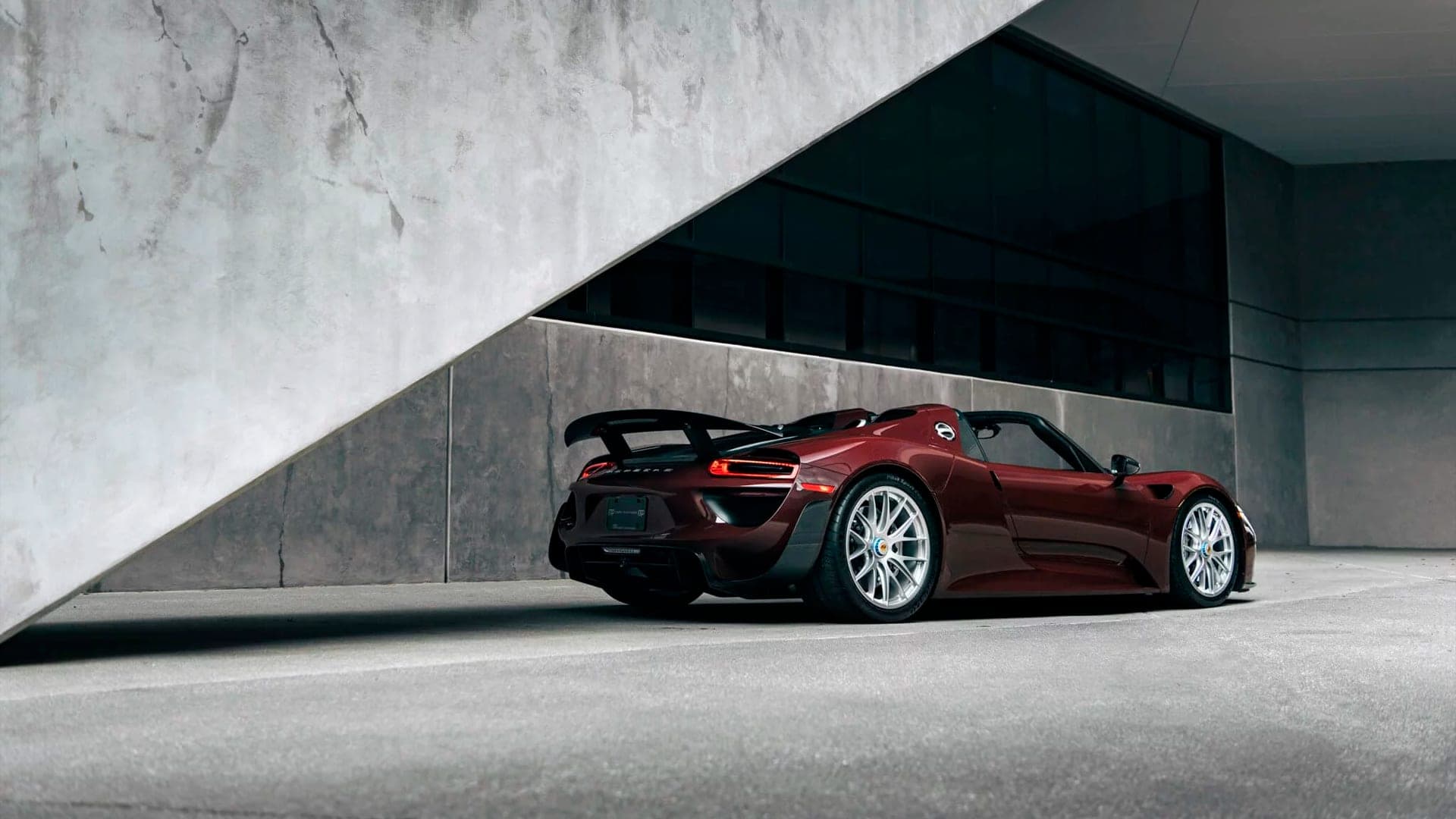 Porsche 918 Spyder parked under a diagonal concrete overhang