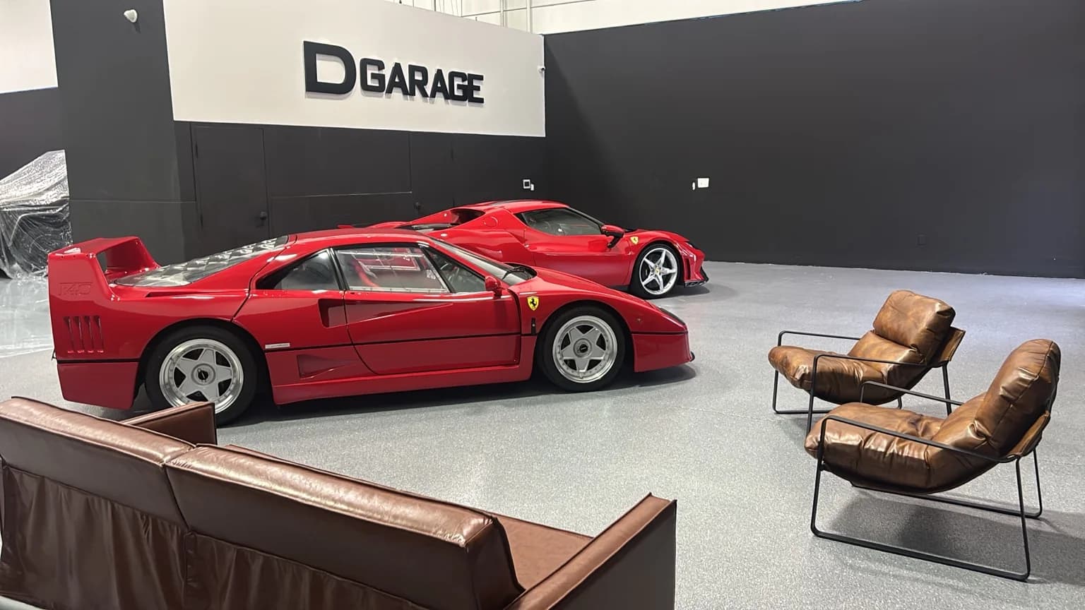 Ferrari F40 and Ferrari 296 beside the collector lounge under the DGarage sign