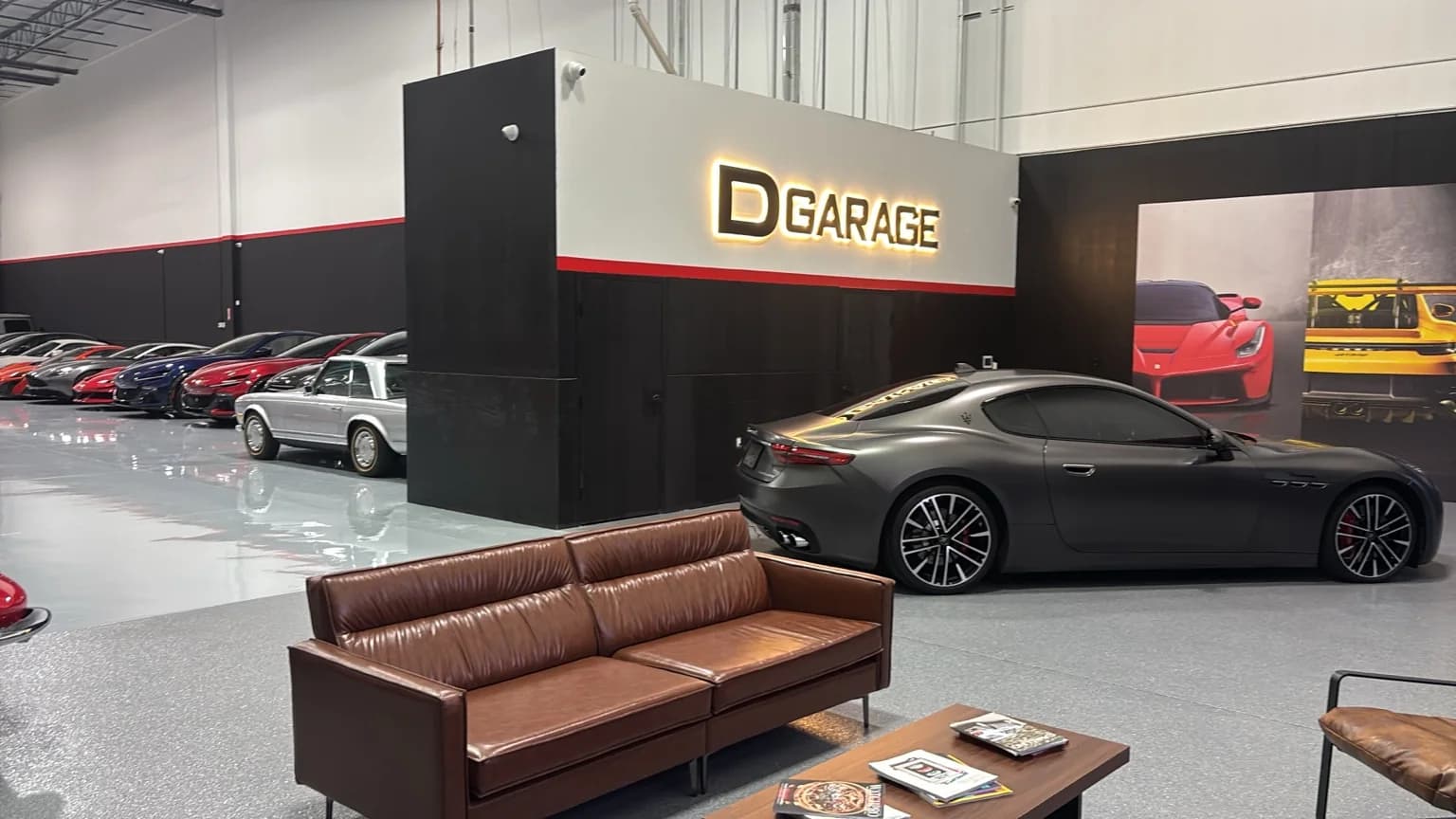 DGarage showroom with its illuminated sign, leather lounge, and a grey Maserati GranTurismo