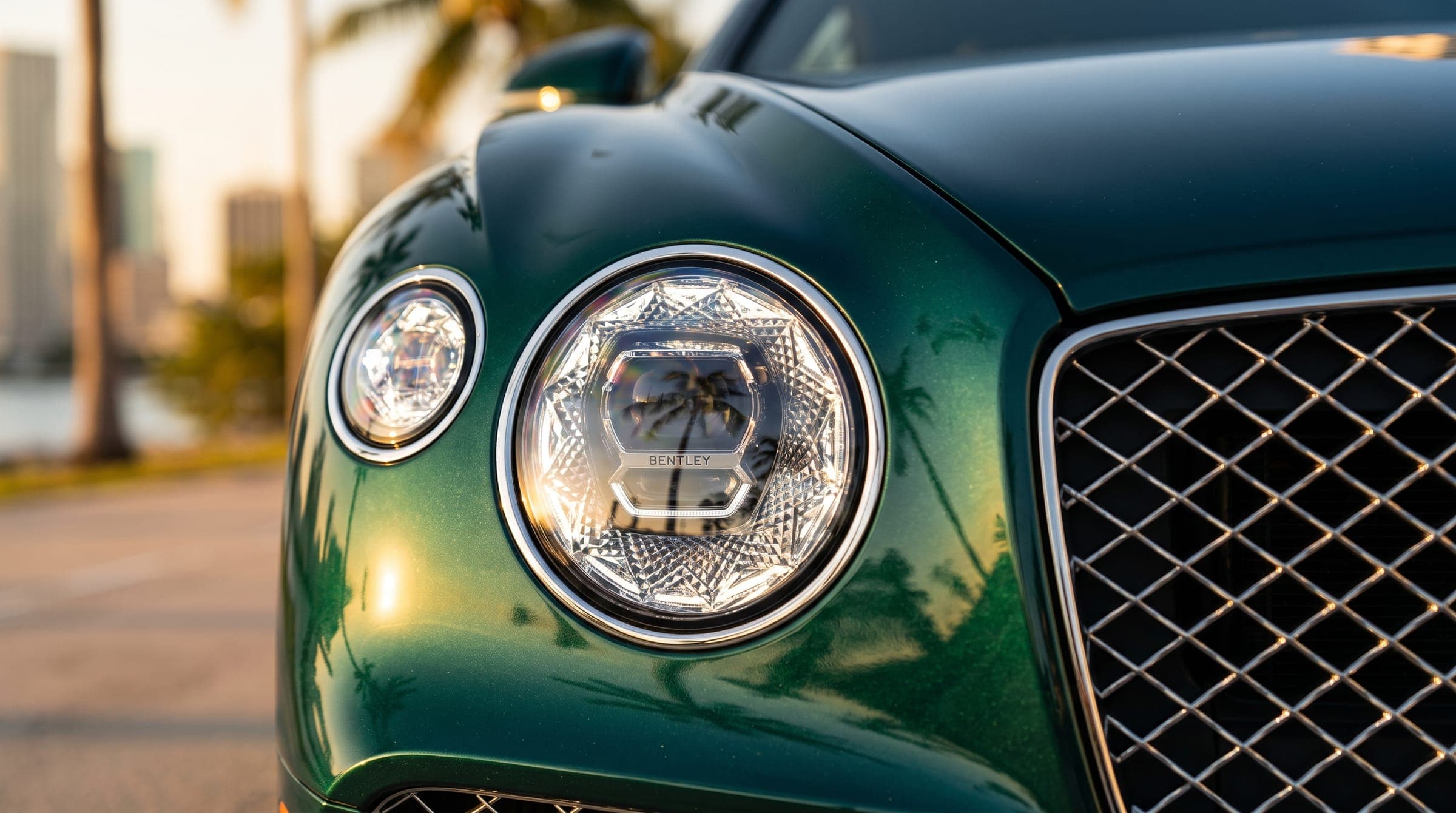 Close-up of a green Bentley Continental GT headlight and grille